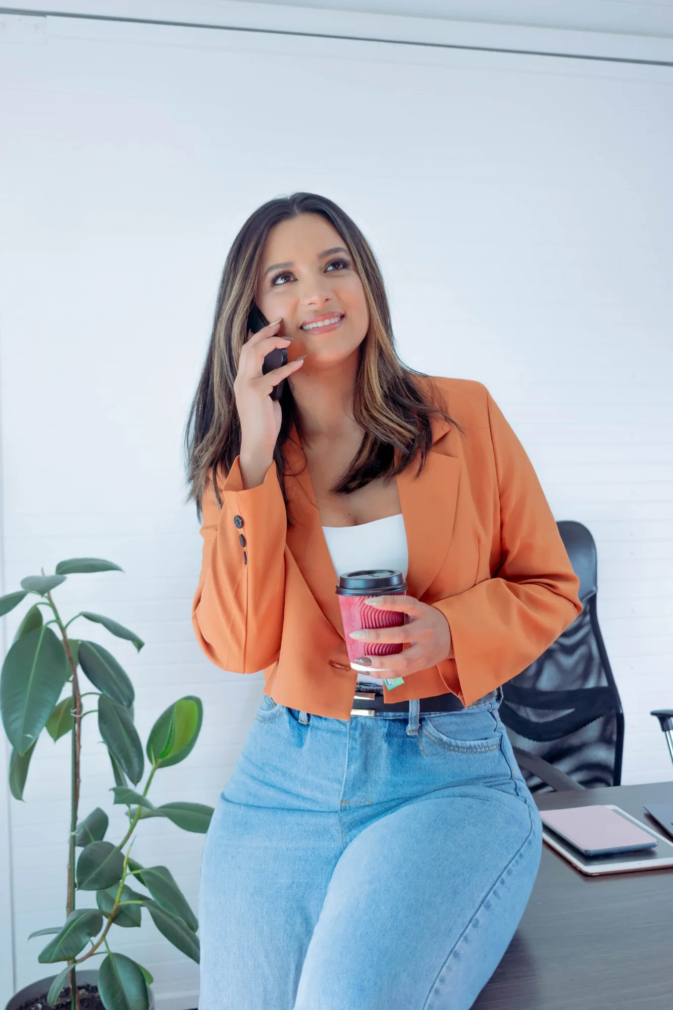 Marlu Sutachán hablando por teléfono con un café en la mano